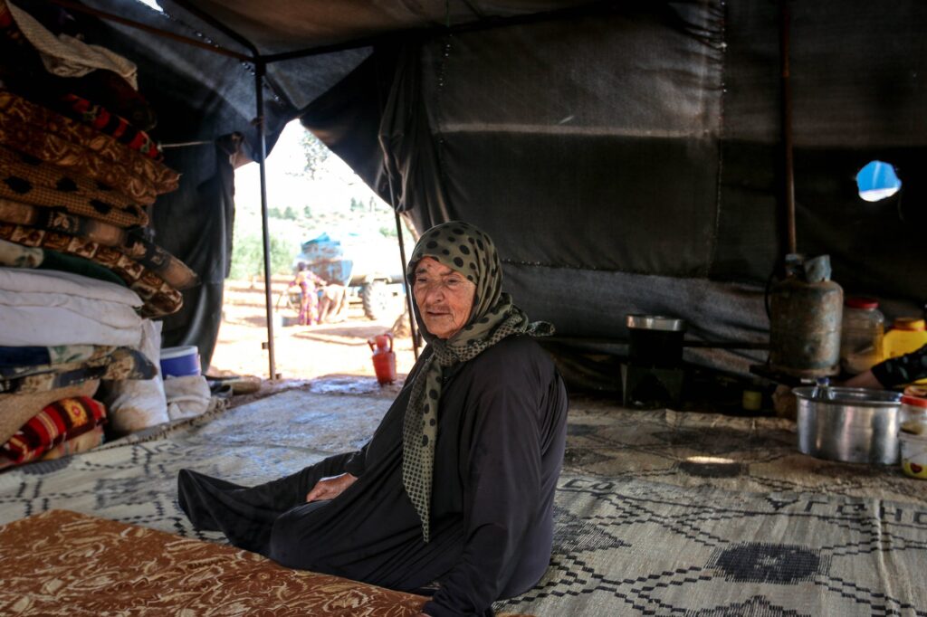 aged woman sitting in tent