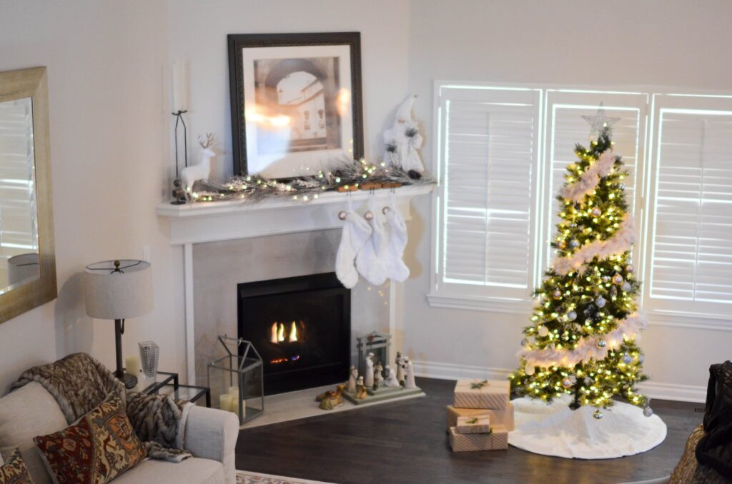 green and white pre lit pine tree near fireplace inside well lit room