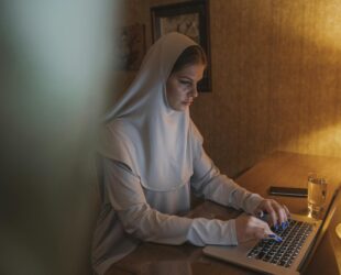 woman in white hijab using laptop computer