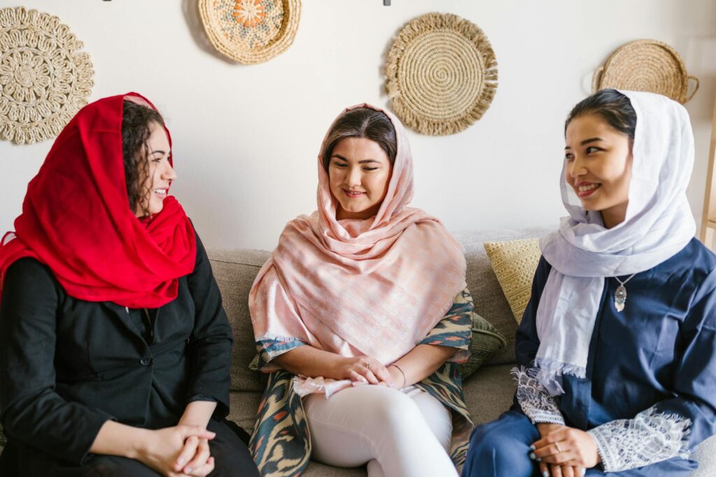 three women with different headscarf sitting on a couch