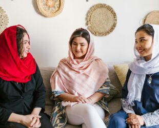 three women with different headscarf sitting on a couch