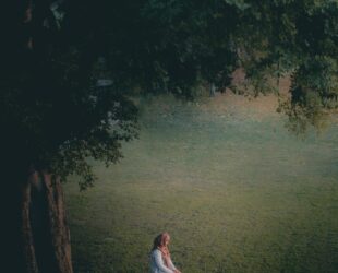 woman in white dress sitting on green grass field