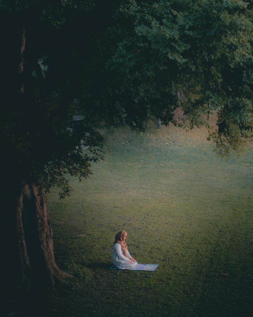 woman in white dress sitting on green grass field