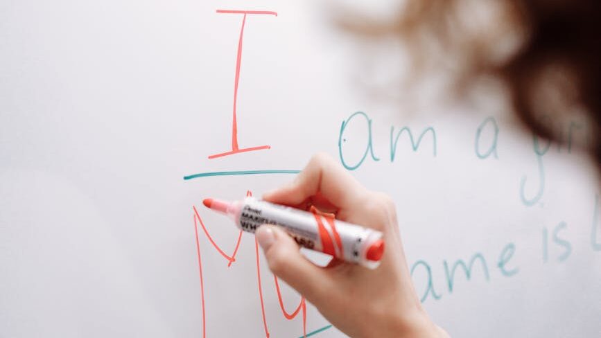 person writing on whiteboard