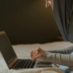 person in gray long sleeve shirt using macbook pro