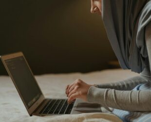 person in gray long sleeve shirt using macbook pro